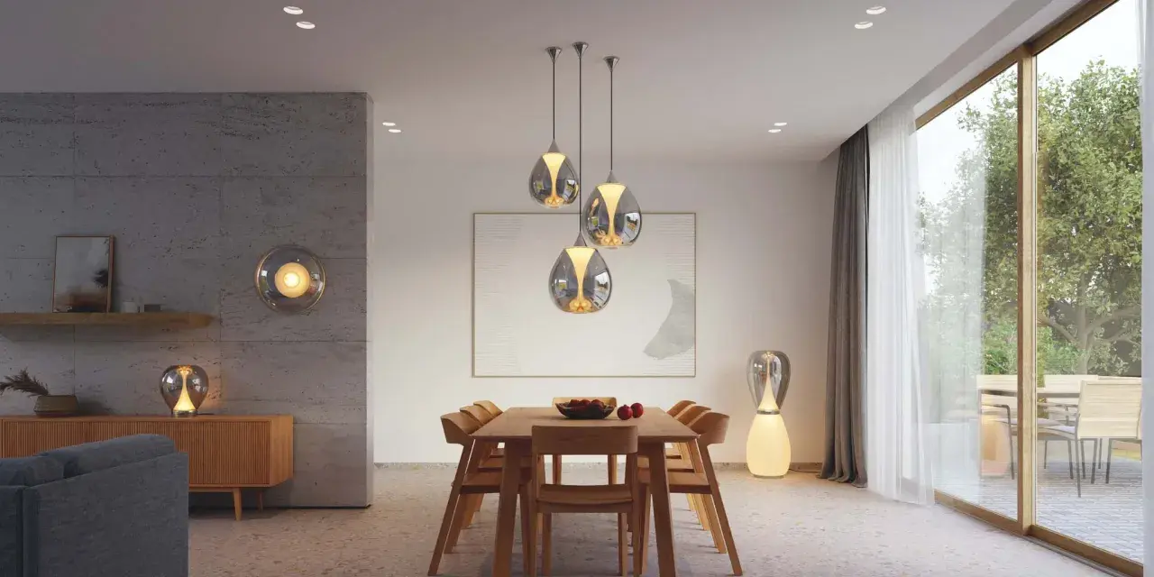 Quel luminaire pour salon salle à manger ? Suspensions modernes au-dessus d'une table en bois, lampe sur pied design et applique murale sphérique créent une ambiance chaleureuse.