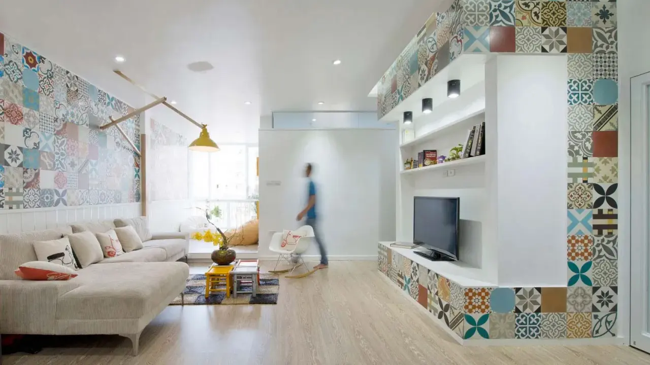 Un salon moderne avec une décoration murale audacieuse. Quelle déco avec des carreaux de ciment ! Le sol en bois clair complète l'ensemble.