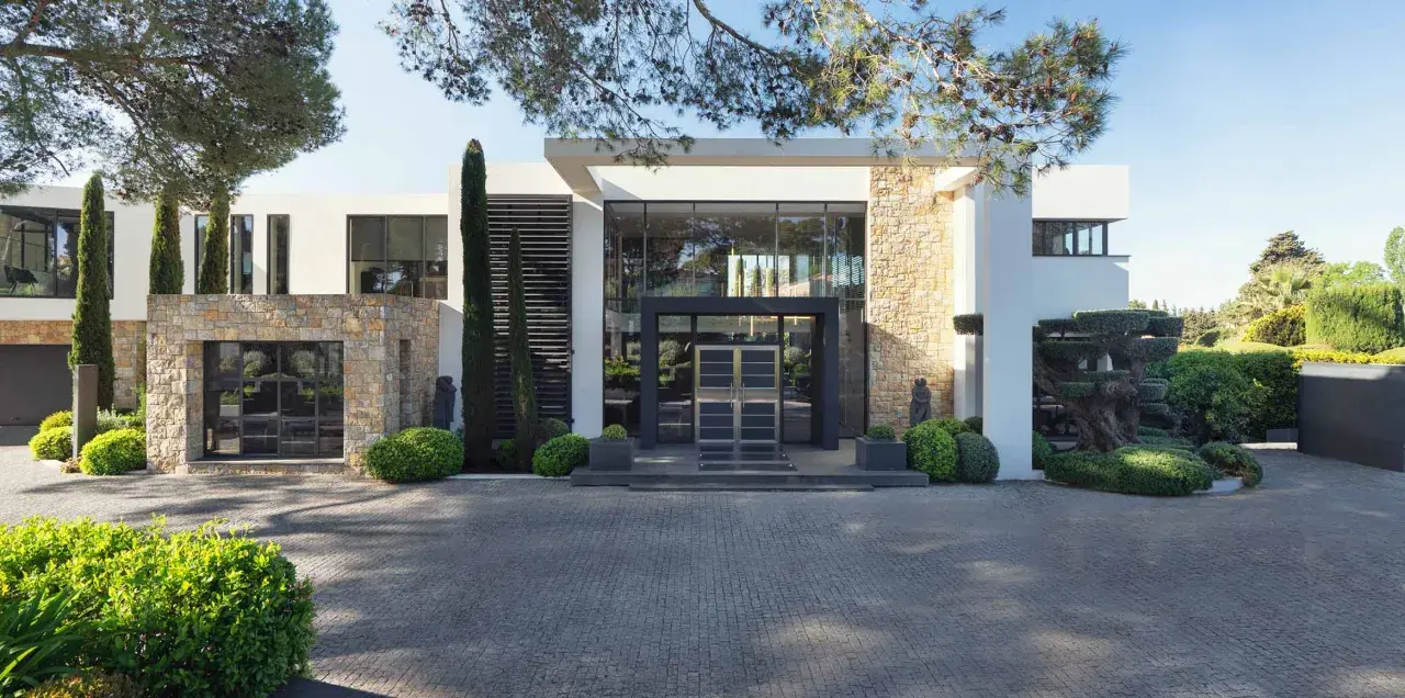 Une villa moderne avec des pierres apparentes et de grandes baies vitrées, parfaite pour construire une maison bioclimatique.