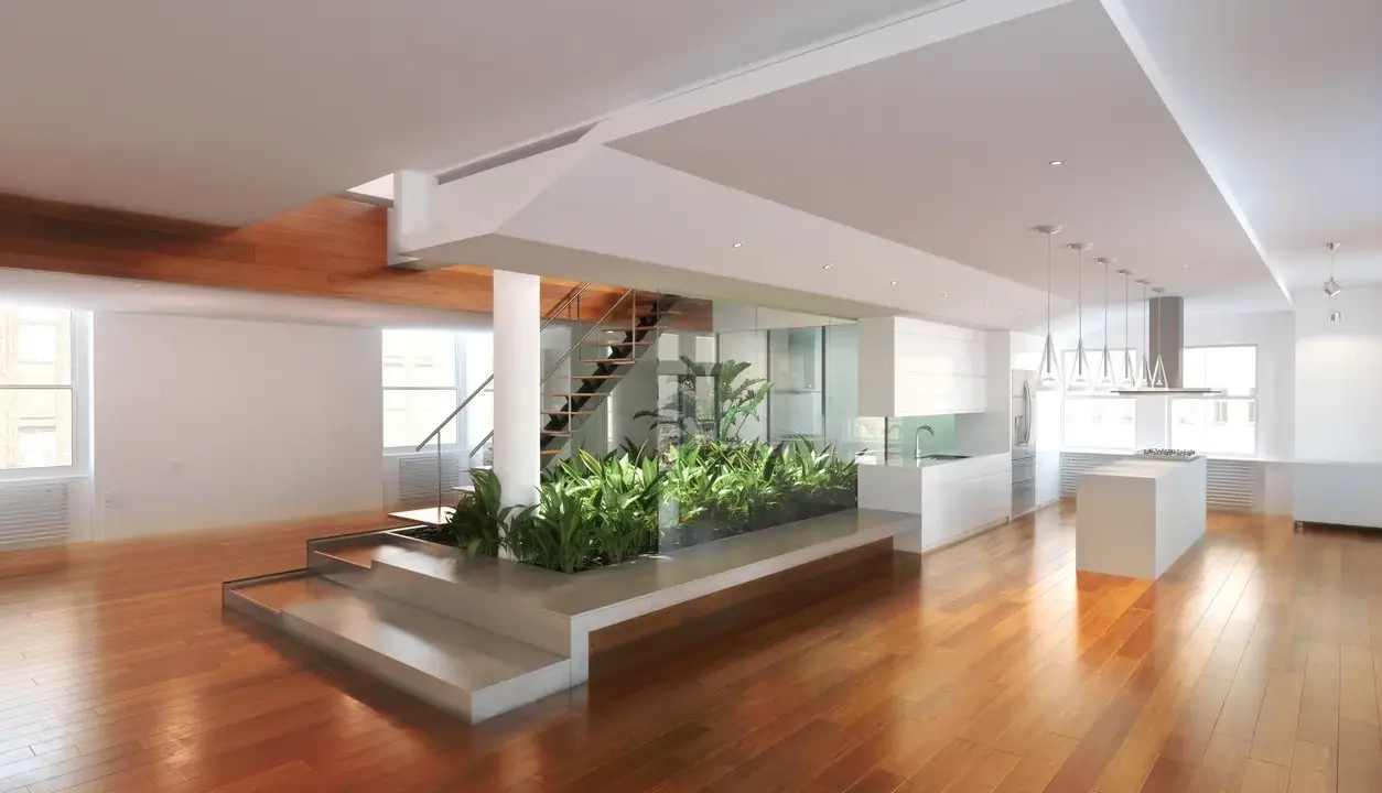 Un grand espace ouvert avec un escalier moderne, une cuisine épurée et un jardin intérieur. Une maison prête à décorer, lumineuse et spacieuse.
