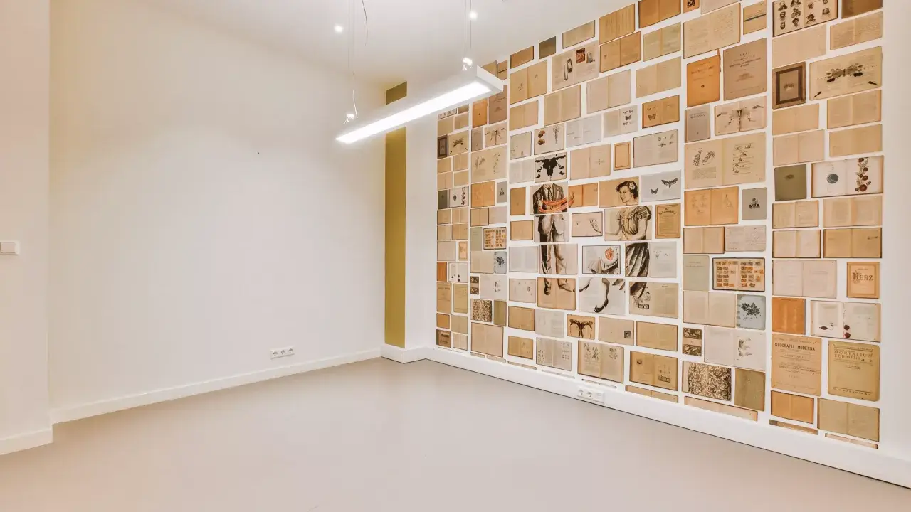 Un mur intérieur décoré de pages de livres anciens, créant une mosaïque d'images et de textes.