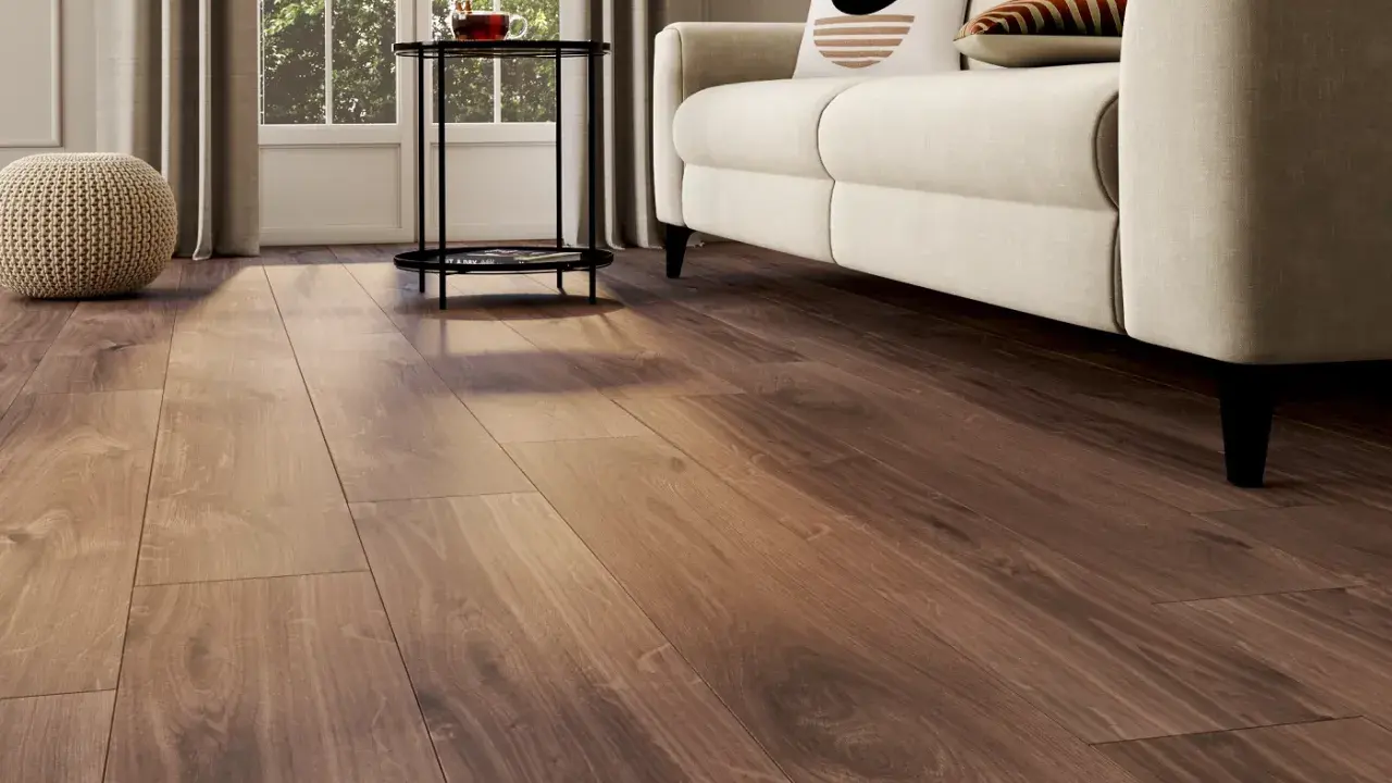 Un salon lumineux avec un nouveau revêtement sol en bois chaleureux, un canapé crème et des coussins décoratifs.