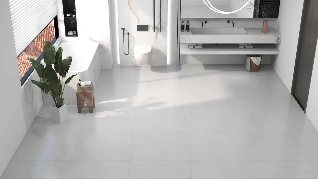 Salle de bain moderne avec baignoire, douche, lavabo et toilettes, le tout sur un sol en dalle pvc ou carrelage blanc.