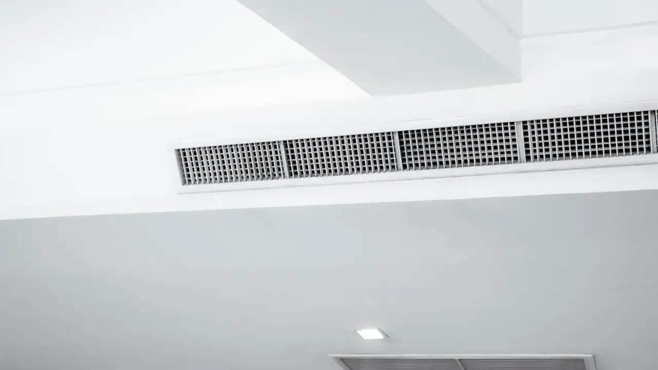 Grille de climatisation par le plafond, discrète et intégrée dans un design moderne pour un confort optimal.