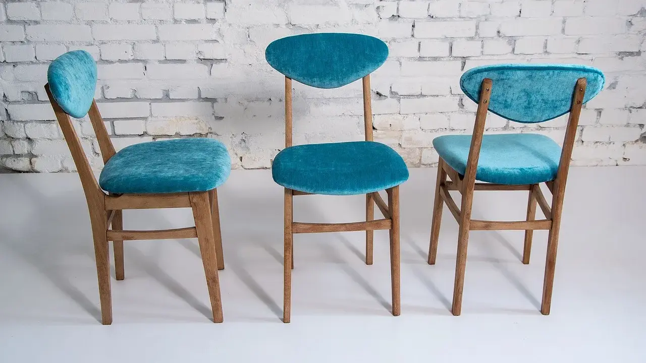 Trois chaises en bois relookées avec un tissu bleu turquoise velouté. Une belle idée déco pour transformer de vieilles chaises.