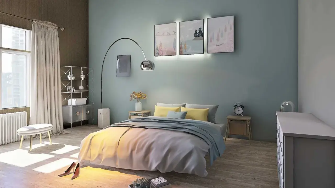 La couleur mur chambre parentale est un bleu-vert doux, créant une ambiance apaisante. Le lit est orné de coussins jaunes et d'une couverture grise.