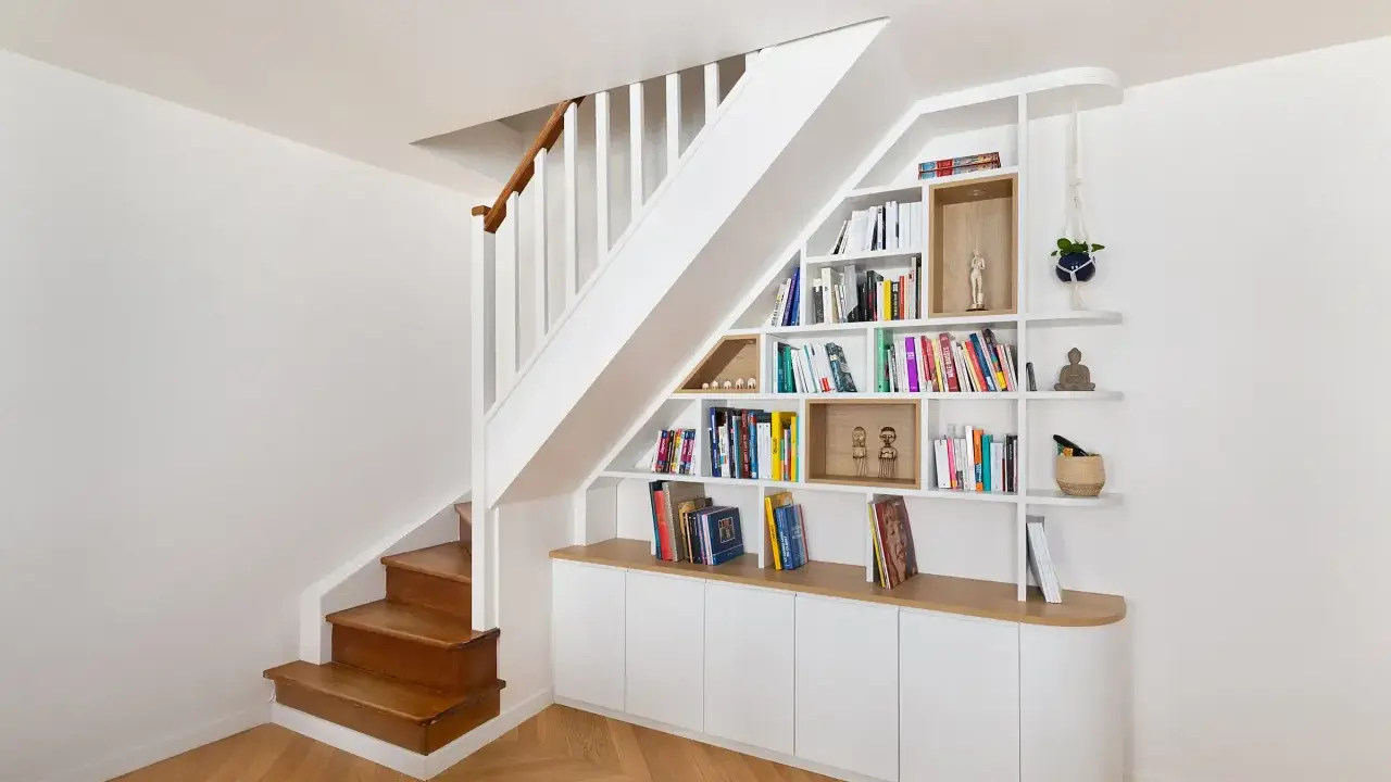 Bibliothèque intégrée dans la cage d'escalier, offrant un espace de rangement astucieux et décoratif.