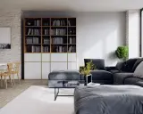 Un salon moderne avec un grand canapé d'angle gris foncé, une bibliothèque remplie de livres, une table basse et une table à manger en bois clair.