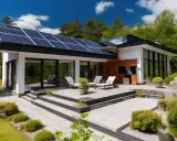 Une maison basse consommation avec des panneaux solaires sur le toit, une terrasse moderne et un jardin verdoyant.