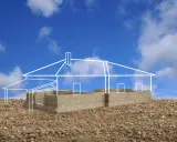 Esquisse d'une maison sur un terrain rocailleux, montrant les fondations en parpaings et le plan blanc de la structure. L'implantation maison sur terrain est en cours.
