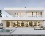 Une maison design moderne avec piscine, de grandes baies vitrées révélant un intérieur lumineux et épuré.
