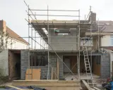 Construction d'une maison : échafaudages, blocs de béton, poutres métalliques. Penser à tout quand on fait construire sa maison.