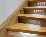 Escalier en bois rénové avec éclairage LED discret. Un design moderne pour un escalier chaleureux.