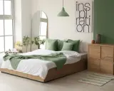 Chambre au nord lumineuse avec murs blancs et un mur vert sauge. Le lit est orné de coussins et d'une couverture vert menthe, apportant une touche de fraîcheur.