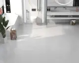 Salle de bain moderne avec baignoire, douche, lavabo et toilettes, le tout sur un sol en dalle pvc ou carrelage blanc.