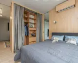 Chambre moderne avec lit douillet, dressing ouvert et rideaux gris. Le prix pour peindre une chambre de 12m2 dépend des finitions.