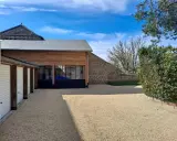 Belle maison tradi pierre Saint Junien avec garage, jardin et ciel bleu.