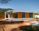 Une maison écologique moderne en bois avec une piscine et une vue sur les montagnes.