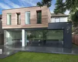 Une extension moderne en bois et anthracite pour agrandir une maison, avec de grandes baies vitrées donnant sur un jardin.