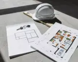 Clés, casque et niveau à bulle sur des plans d'architecte, un aperçu d'un projet de construction. Un plan architecte gratuit pour concrétiser vos rêves.