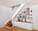 Bibliothèque intégrée dans la cage d'escalier, offrant un espace de rangement astucieux et décoratif.