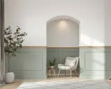 Un salon moderne avec un soubassement de mur peint en vert pâle, orné de moulures. Une niche cintrée au-dessus apporte une touche architecturale.