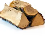 Bûches de bois de chauffage empilées, prêtes pour l'hiver. Le prix de la tonne de bois de chauffage varie selon la saison.