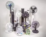 Collection de différents types de ventilateurs : sur pied, colonne, de table et même un petit modèle vert.