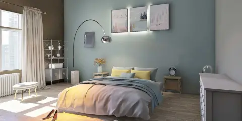 La couleur mur chambre parentale est un bleu-vert doux, créant une ambiance apaisante. Le lit est orné de coussins jaunes et d'une couverture grise.