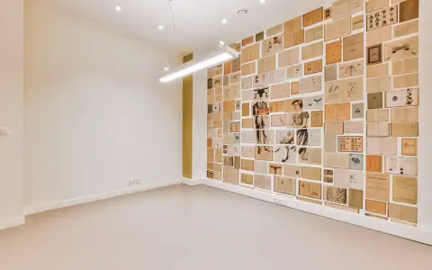 Un mur intérieur décoré de pages de livres anciens, créant une mosaïque d'images et de textes.