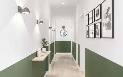Un couloir moderne avec un soubassement vert, des appliques murales, une étagère en bois et des cadres photo.