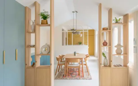 Aménagement d'une **plan maison en longueur** avec cloisons ajourées en bois, salle à manger et cuisine ouverte.