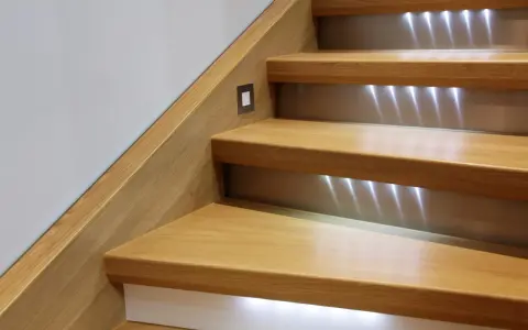 Escalier en bois rénové avec éclairage LED discret. Un design moderne pour un escalier chaleureux.
