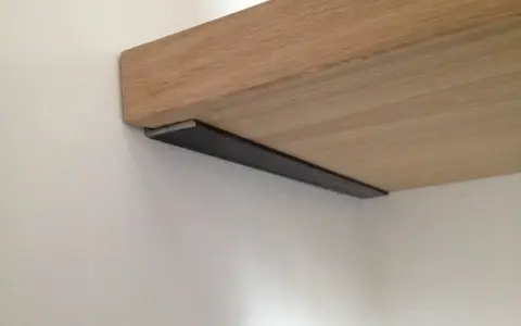 Étagère en bois fixée au mur avec un support discret. Idéal pour fixer une étagère murale.