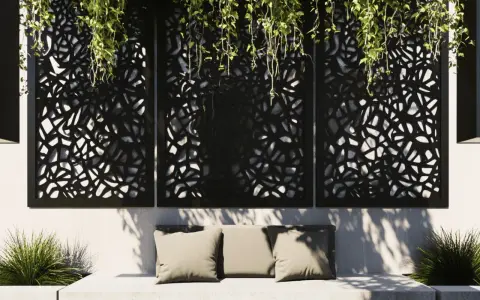 Comment cacher un vilain mur extérieur : des panneaux ajourés noirs avec des plantes retombantes créent une ambiance cosy sur un banc.