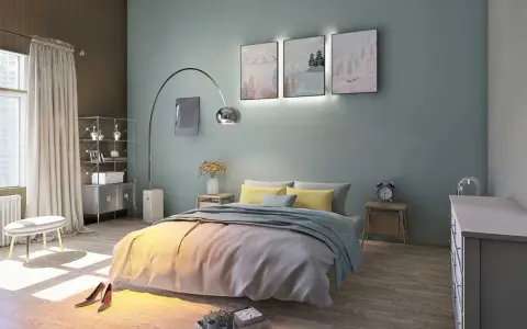 La couleur mur chambre parentale est un bleu-vert doux, créant une ambiance apaisante. Le lit est orné de coussins jaunes et d'une couverture grise.