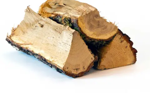 Bûches de bois de chauffage empilées, prêtes pour l'hiver. Le prix de la tonne de bois de chauffage varie selon la saison.