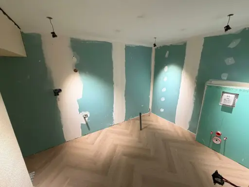 Chantier en cours : murs en Placo vert, sol parquet chevron. Idéal pour estimer le prix pose placo m2.