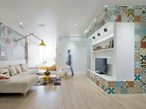 Un salon moderne avec une décoration murale audacieuse. Quelle déco avec des carreaux de ciment ! Le sol en bois clair complète l'ensemble.