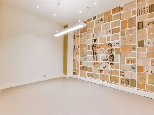 Un mur intérieur décoré de pages de livres anciens, créant une mosaïque d'images et de textes.