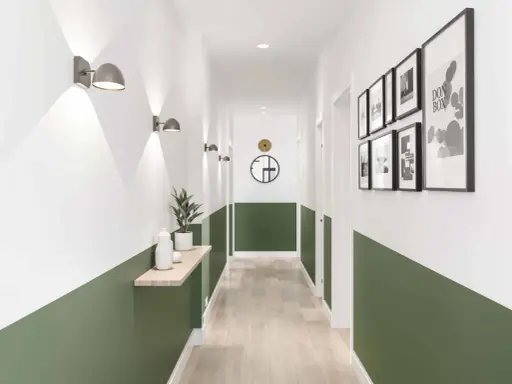 Un couloir moderne avec un soubassement vert, des appliques murales, une étagère en bois et des cadres photo.