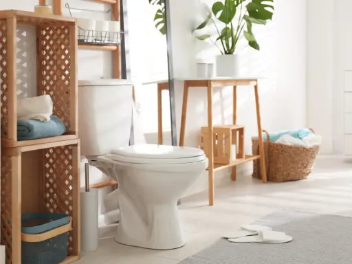 Idées pour comment décorer des toilettes : étagères en bois, paniers tressés, plantes vertes et serviettes douces créent une ambiance chaleureuse.