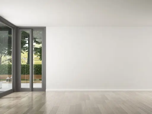 Un salon lumineux avec de grandes baies vitrées donnant sur un jardin verdoyant. Le parquet clair est parfait pour refaire le sol de la maison.