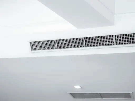 Grille de climatisation par le plafond, discrète et intégrée dans un design moderne pour un confort optimal.