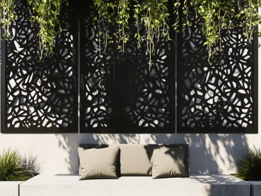 Comment cacher un vilain mur extérieur : des panneaux ajourés noirs avec des plantes retombantes créent une ambiance cosy sur un banc.