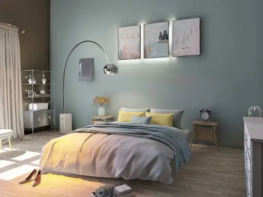 La couleur mur chambre parentale est un bleu-vert doux, créant une ambiance apaisante. Le lit est orné de coussins jaunes et d'une couverture grise.