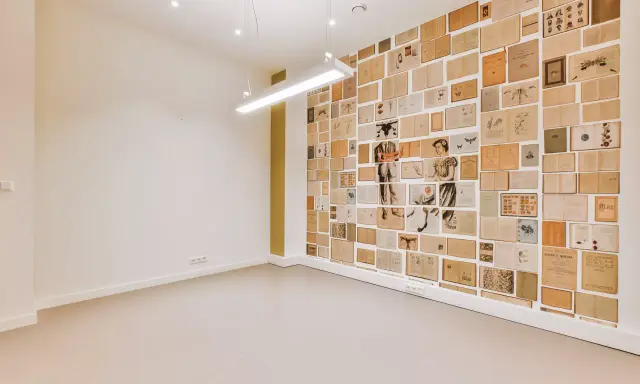 Un mur intérieur décoré de pages de livres anciens, créant une mosaïque d'images et de textes.