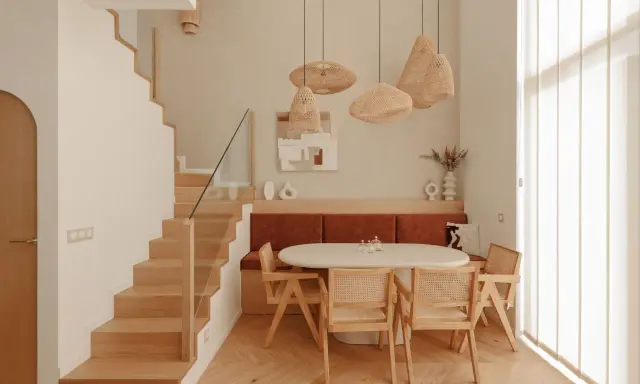 Plan salle à manger avec banquette, table ovale et chaises en rotin. Escalier en bois à gauche.
