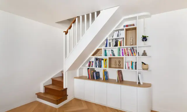 Bibliothèque intégrée dans la cage d'escalier, offrant un espace de rangement astucieux et décoratif.