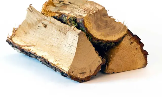 Bûches de bois de chauffage empilées, prêtes pour l'hiver. Le prix de la tonne de bois de chauffage varie selon la saison.